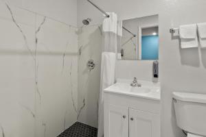een witte badkamer met douche en wastafel bij Rodeway Inn in Palestine +14 foto's