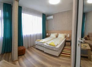 a bedroom with a bed and a large window at Hotel Rade 1 in Vratsa