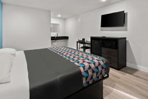 um quarto com uma cama e uma televisão de ecrã plano em Rodeway Inn em Palestine