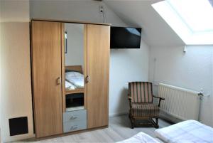 - une chambre avec une armoire en bois et une chaise dans l'établissement Apartment Kraemer Dax, à Mehren