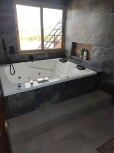 baño con bañera grande y ventana en Terraza, Casa, Cabaña, Campo, en Arandas