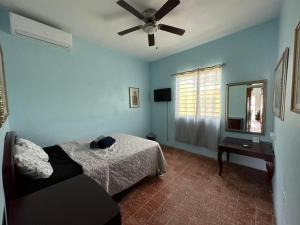 1 dormitorio con 1 cama y ventilador de techo en Best Surfers Beach just a few block down, Arecibo Main House, en Arecibo