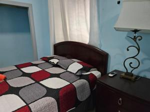 a bedroom with a bed and a table with a lamp at Best Surfers Beach just a few block down, Arecibo Main House in Arecibo