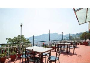 a row of tables and chairs on a balcony at Hotel Valley View, Mussoorie in Mussoorie