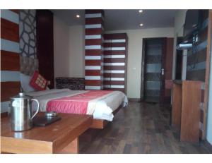 a bedroom with a bed and a wooden table and a table at Hotel Valley View, Mussoorie in Mussoorie