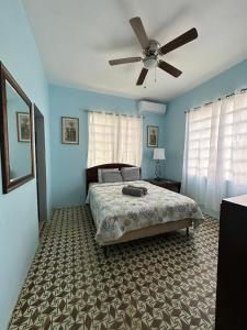 1 dormitorio con 1 cama y ventilador de techo en Best Surfers Beach just a few block down, Arecibo Main House en Arecibo