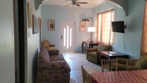 a living room with a couch and a table at Best Surfers Beach just a few block down, Arecibo Main House in Arecibo