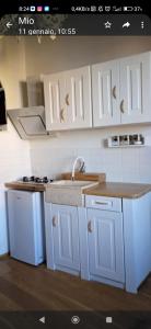 a kitchen with white cabinets and a sink at Da Nori bed and relax in Orbetello