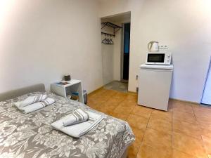 a bedroom with a bed and a microwave on a refrigerator at Gero poilsio in Nida