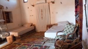 Habitación con 2 camas y 2 sillas. en مراقي سيوة Maraqi Siwa, en Siwa