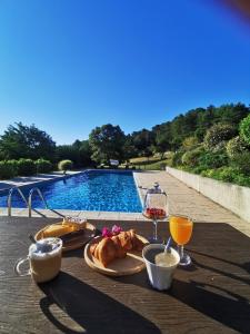 een tafel met eten en drinken naast een zwembad bij Appartements Vallée Verte in Razac-sur-lʼIsle