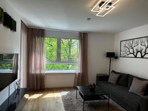 a living room with a couch and a large window at 10 minutes to the center, 2 minutes to the metro in Vienna