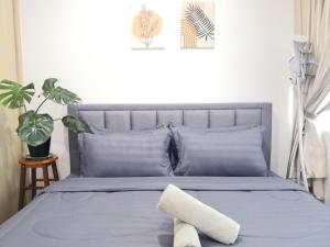 a bedroom with a bed with blue sheets and a plant at Hanns&KingBed&WIFI@ComfortStay4 in Sibu