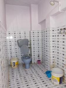 a bathroom with a toilet and buckets in it at Hotel Old Moon Cafe in Pushkar