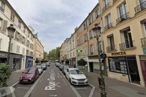 una calle de la ciudad con coches aparcados en la calle en Le Cosy Macaron - Au cœur de Versailles, en Versalles