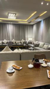 a living room with couches and a table with pizza on it at Tola Holiday House Al Rimal in Riyadh +148 photos