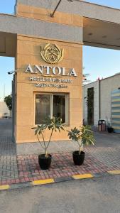 a building with two potted plants in front of it at Antola Resort Al Rimal in Riyadh