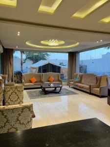 a large living room with couches and a table at Tola Holiday House Al Rimal in Riyadh