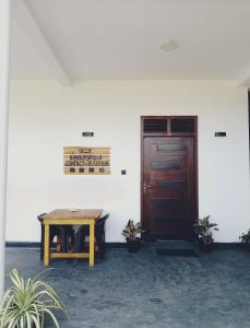 una mesa de madera en una habitación con puerta en Villa kandupamula, en Mirissa