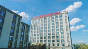 a white building with a red sign on top of it at LC International Hotel 