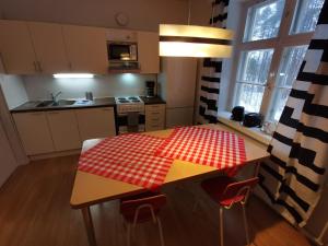 una cucina con tavolo e panna a scacchi rossa e bianca di Beautiful 2 Bed Apartment Sauna Facility in Kotka a Kotka