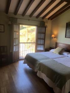 a bedroom with a large bed and a large window at Casa Rural Trebol4Hojas in San Pedro