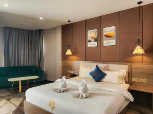 Habitación de hotel con cama y sofá verde en Sunshine Hotel, en Phnom Penh