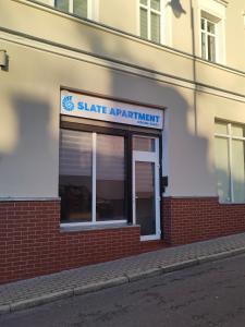 a sign for a state apartment building on the side of a building at Slate Apartament Jedlina - Zdrój in Jedlina-Zdrój