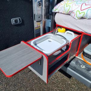 uma bandeja com um lavatório na cama de uma caravana em Electric Minicamper blue em Askøy