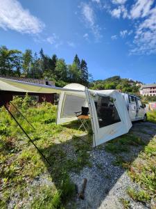 uma tenda e uma carrinha estacionada num campo em Electric Minicamper blue em Askøy