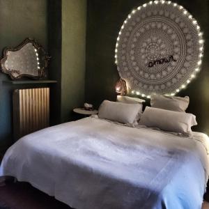 una camera da letto con un grande letto bianco e uno specchio di RaMaya casa d'artista 2 a Biella