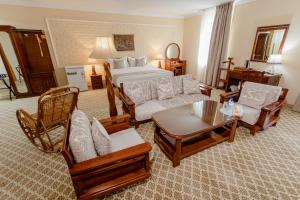 Hotel Grand Samarkand Superior - B في سمرقند: غرفة معيشة مع سرير وأريكة وكراسي