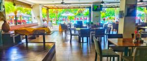 a restaurant with tables and chairs and a large window at The Bay Sunflower Apartment in Nusa Dua
