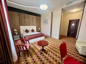 Pokój hotelowy z łóżkiem, stołem i krzesłem w obiekcie Armenian Royal Palace w Erywaniu
