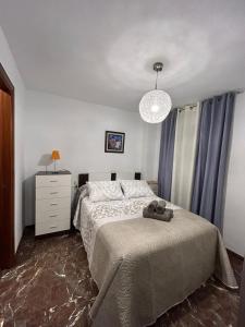 a bedroom with a bed and a chandelier at APARTAMENTO GARCIA REQUENA in Jaén