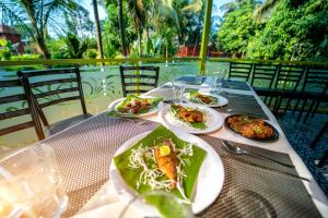 a table with plates of food on top of it at Coconut Greenland Resort in Nagaon