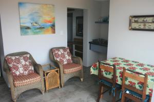 a room with two chairs and a table and a painting at House of 2 Oceans in Agulhas