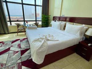 Cama en habitación de hotel con ventana grande en فندق ماريوت عدن السياحي Marriott Aden Hotel, en Khawr Maksar