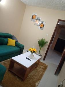 a living room with a green couch and a coffee table at Embu Paradise 1 bedroom AirBNB in Embu