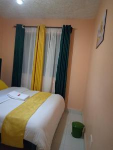 a bedroom with a bed with green and yellow curtains at Embu Paradise 1 bedroom AirBNB in Embu