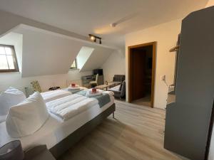 ein Schlafzimmer mit einem großen Bett und ein Wohnzimmer in der Unterkunft Hotel Der Distelhof in Dillstädt