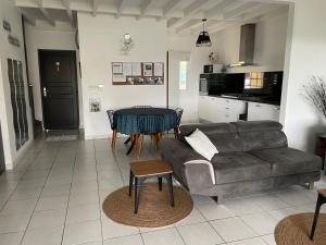 a living room with a couch and a table at Le logis des 3 Vallées in Koungou