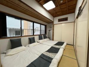 uma cama grande num quarto com uma janela em Le Tour Hotel Akihabara Kandai 楽途ホテル神田秋葉原 em Tóquio