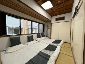 a large bed in a room with a window at Le Tour Hotel Akihabara Kandai 楽途ホテル神田秋葉原 in Tokyo