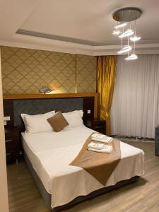 a bedroom with a large bed with white sheets at Avşa Blue Sea Otel in Marmara
