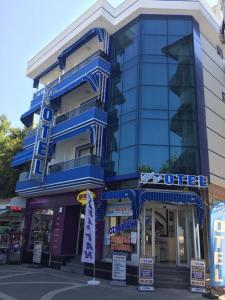 a tall blue building with signs in front of it at Avşa Blue Sea Otel in Marmara