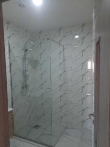 a bathroom with a shower with a glass door at Résidence amira 5 in Oran