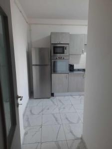 a kitchen with stainless steel appliances and a tile floor at Résidence amira 5 in Oran