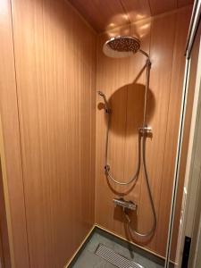 y baño con ducha y pared de madera. en 【ペット可】Niseko STREAM Villas, en Rankoshi