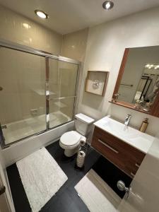 a bathroom with a shower and a toilet and a sink at Cozy Private Condo near Hall of Fame in Hollywood in Los Angeles